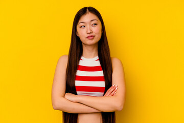 Young chinese woman isolated on yellow background dreaming of achieving goals and purposes