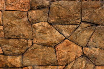 Fototapeta premium Old weathered wall made of granite stones, abstract background.