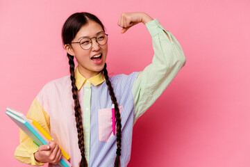 Young chinese student woman holding books wearing a fashion multicolour shirt and braid, isolated...