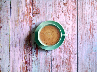 Blue coffee cup and saucer shot on wooden surface. Top view, from above, flat lay. Coffee break background.