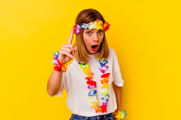 Young caucasian woman celebrating a hawaiian party isolated on yellow background having an idea,...