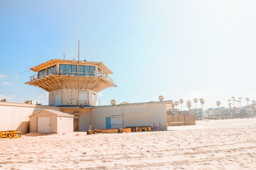 Fototapeta na wymiar Sandy beach at Venice Beach in Los Angeles, blue lifeguard towers on a sunny day