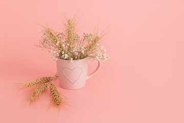 Pink mug with a picture of a heart and a bouquet of white flowers and ears of wheat. Wheat ears...
