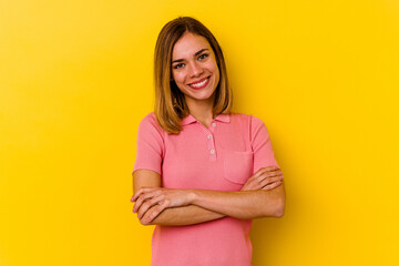 Young caucasian skinny woman isolated on yellow background who feels confident, crossing arms with determination.