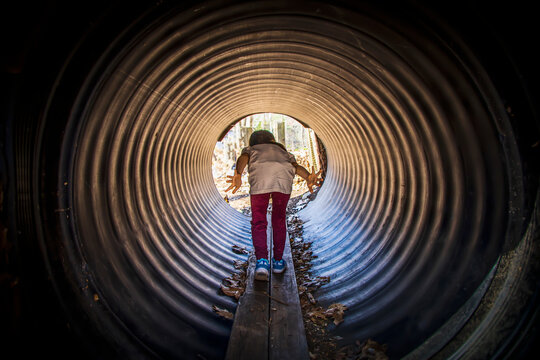 Little child going through a tunnel in a playground