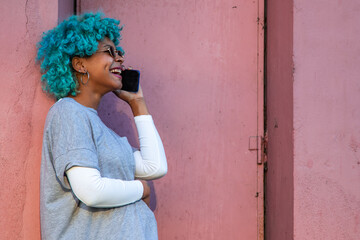 afro american girl with colored hair and mobile phone on the street