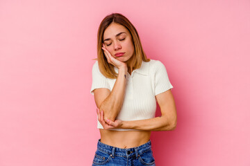 Young caucasian woman isolated on pink background who is bored, fatigued and need a relax day.