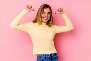 Young caucasian woman isolated on pink background feels proud and self confident, example to follow.