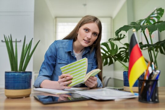 Female student looking talking to webcam, studying German online
