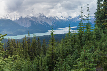 Clouds gathering above the mountain range in Canadian Rockies. Pretty Maligne lake in Jasper national park, Alberta, viewed from Bald Hills trail.