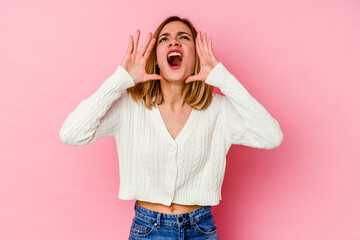 Young caucasian woman isolated on pink background shouting excited to front.