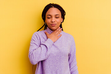 Young african american woman isolated on yellow background suffers pain in throat due a virus or...