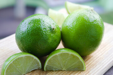 Whole lemon with some slices on a wooden board