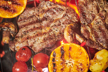 Assorted delicious grilled meat with vegetables on a grill