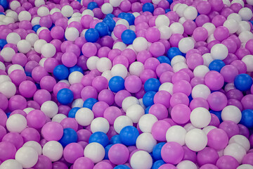 Heap of colorful plastic balls in white, blue and purple colors.