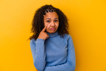 Young african american woman isolated on yellow background crying, unhappy with something, agony and confusion concept.
