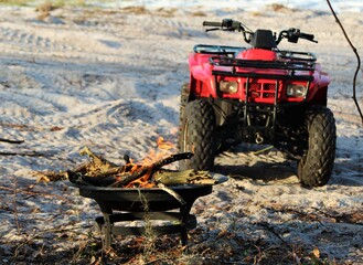Selective focus on campfire with atv in the background at a camp site. © Bluee