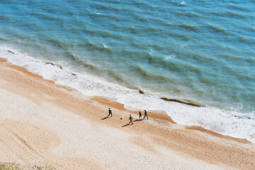 Aerial Top view family walking on the beach on a sunny day. Calming and enjoying life. Emotional wellness. Happiness is in simple things. Copy space