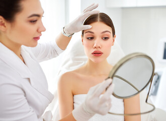 Cosmetologist and client with mirror after skin care procedure
