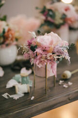 Beautiful floral composition with fresh flowers on wooden table in floristic studio.