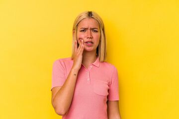Young venezuelan woman isolated on yellow background having a strong teeth pain, molar ache.