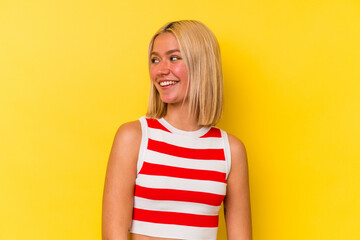 Young venezuelan woman isolated on yellow background looks aside smiling, cheerful and pleasant.