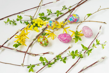 Obraz na płótnie Canvas Easter Background with chocolate eggs, yellow flowers, Pussy Willow Branches, flat lay. Spring holiday concept
