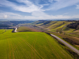 Road in the middle of an idyllic countryside landscape. Drone view, aerial shot.