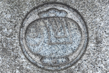 Close up  on a granite stone surface adorned with a symbol depicting the Japanese magic mallet uchide no kozuchi of Daikokuten god part of the seven lucky gods.