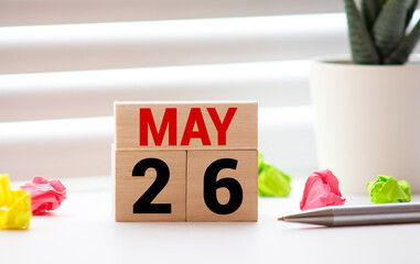 White block calendar present date 26 and month May on wood background