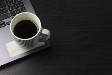computador y café en fondo negro