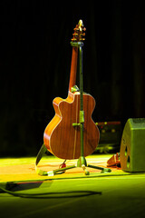 Classic acoustic guitar in stage lights on black background