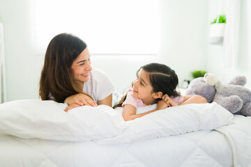 Fototapeta premium Loving mother waking up with her cute daughter