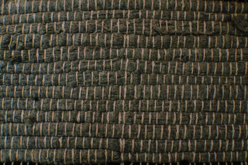 Woven surface from interwoven gray rags and thread of different colors, carpet fragment