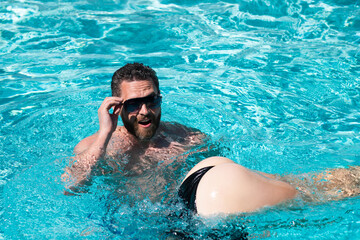 Fototapeta na wymiar Sexy summer couple. Pool resort. Buttocks in bikini. Summertime vacation.
