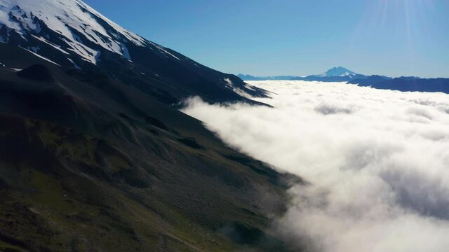 Aerial truck shot showing the mountain ranges of National Park Vicente Perez Rosales in Chile, low lying clouds.
