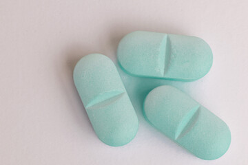 Three light blue medicine tablet