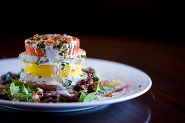 Tomato and mozzarella salad. Classic American salad with romaine, Caesar dressing, red onions, bacon, Parmesan cheese, olive oil, lemon juice, salt and pepper. A Fine dining restaurant classic.
