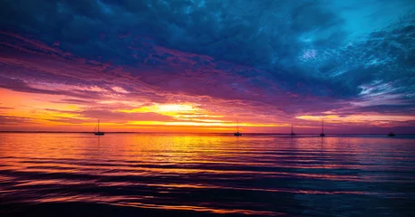 Fotobehang Zonsondergang of zonsopgang in de oceaan, de achtergrond van het natuurlandschap, roze wolken die in de lucht vliegen naar de stralende zon. Avond of ochtend uitzicht. © Volodymyr
