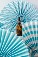 Face serum on a blue background. Aroma oil in a dark glass bottle. Skin health. Unisex essence for men and women. Spa cosmetics for beauty