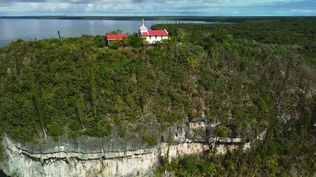 Aerial view of a hilltop Chapel, in Lifou, New Caledonia - circling, drone shot