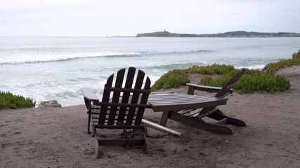 Panorama view of wooden chairs and a table overlooking at the beach - Powered by Adobe
