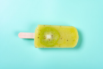 fresh watermelon and pineapple flavor popsicle with slice of kiwi fruit on a light green background