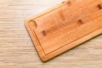 Old chopping board on wooden background top view