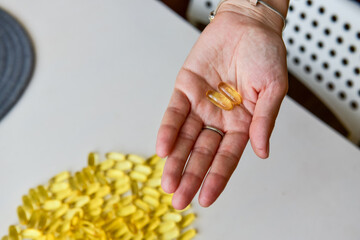 Obraz premium Hand holding fish oil Omega-3 capsules. Medical healthcare, healthy nutrition supplements concept. Vitamin tablets
