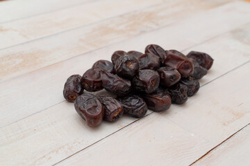 Fresh date fruits pile on white wooden background. Healthy food. Fast food. Food for vegetarians. Top view.  Ramadan ( ramazan ) food backgrounds.