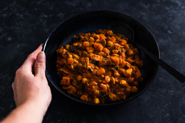 vegan chickpeas and pumpkin curry with diced tomato spinach and coconut milk, healthy plant-based food