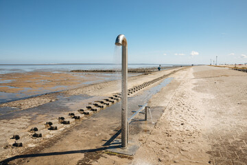 Duschen Sie am Strand an der Nordsee in Deutschland oder den Niederlanden. Gepflasterter Strand an der Nordsee