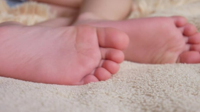 Close-up of a little boys feet fidgeting on a soft bed
