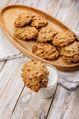 Top view homemade oatmeal cookies and milk. Homemade gluten and sugar free recipe. Rustic wooden background and linen napkin. Delicious and healthy sweets. Vertical photography